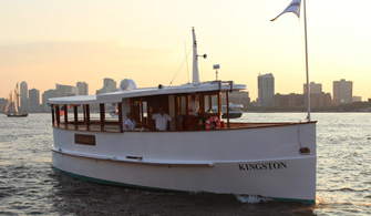 a yacht with the words "Kingston" written on the side, sailing down a river